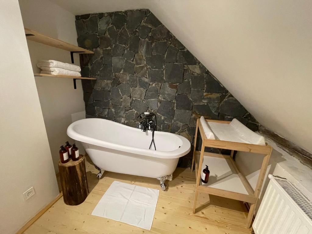 e bagno con vasca e parete in pietra. di Chalupa U Fílů a Lovečkovice