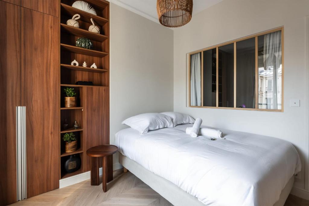 une chambre avec un lit blanc et une fenêtre dans l'établissement Appartement Aulne - Welkeys, à Paris