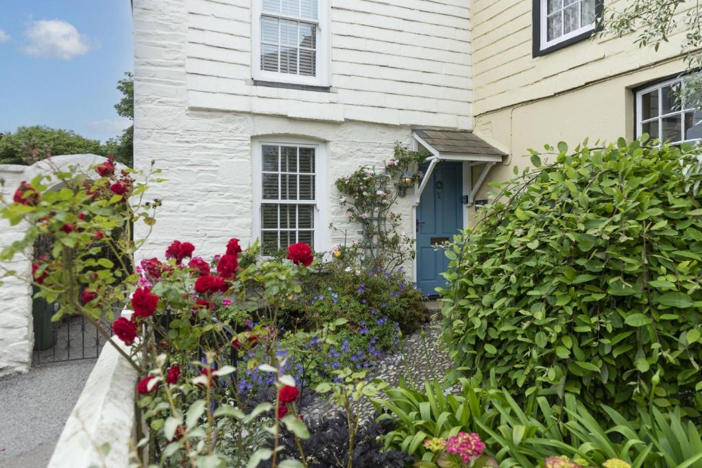 a house with a garden of flowers in front of it at Cob Cottage in St. Agnes