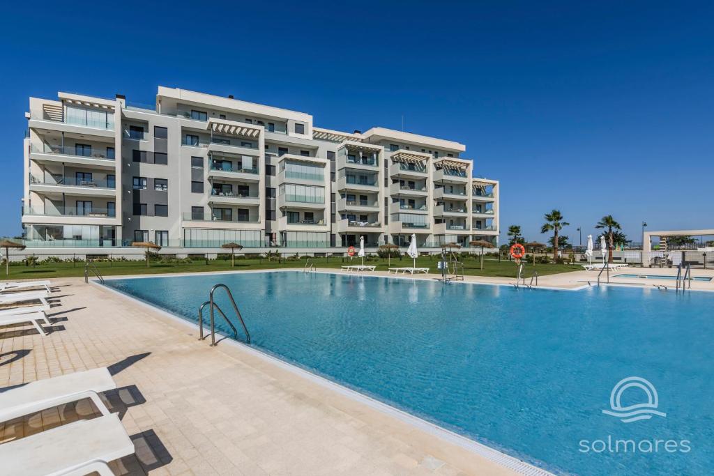 a large apartment building with a large swimming pool at Los Camaleones EXCELLENT & SOLMARES in Isla Canela