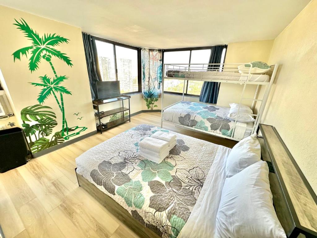 a bedroom with two bunk beds and a tv at Ocean Canal Mountain View Steps from Waikiki Beach 6person in Honolulu