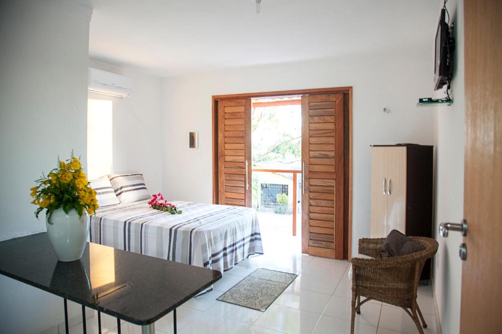 a bedroom with a bed and a table and a table sidx sidx sidx at Mandacaru Flat in São Miguel do Gostoso