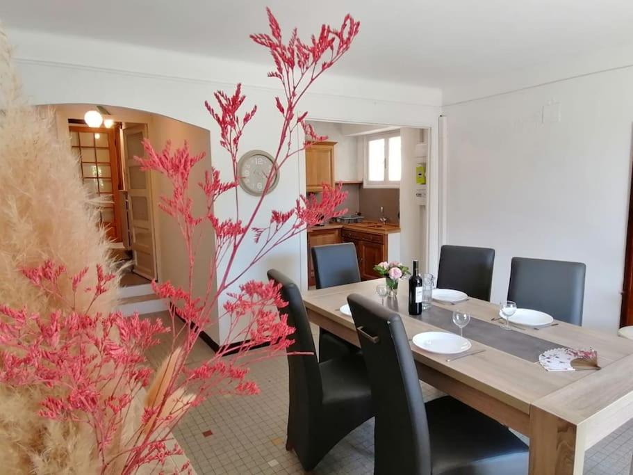 une salle à manger avec une table et des chaises en bois dans l'établissement Le Murier en Ardèche, 10 personnes, avec sauna, à Saint-Marcel-dʼArdèche