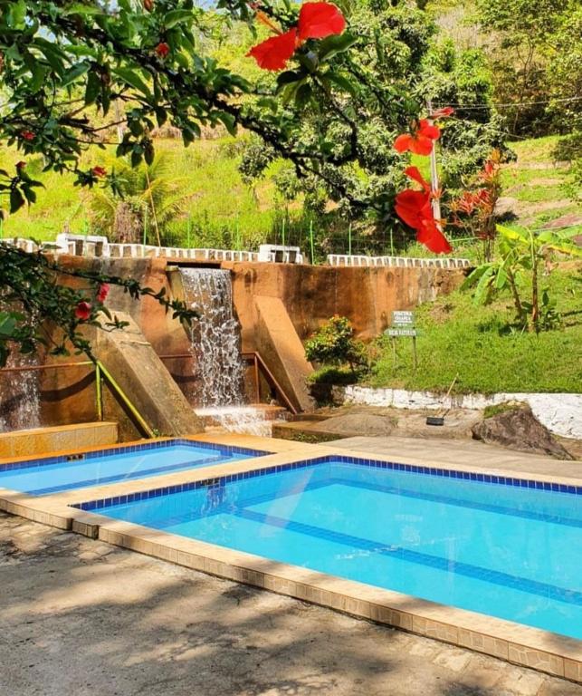 a swimming pool with a waterfall in a yard at Flats Pedra do Rodeadouro Hotel Fazenda in Bonito