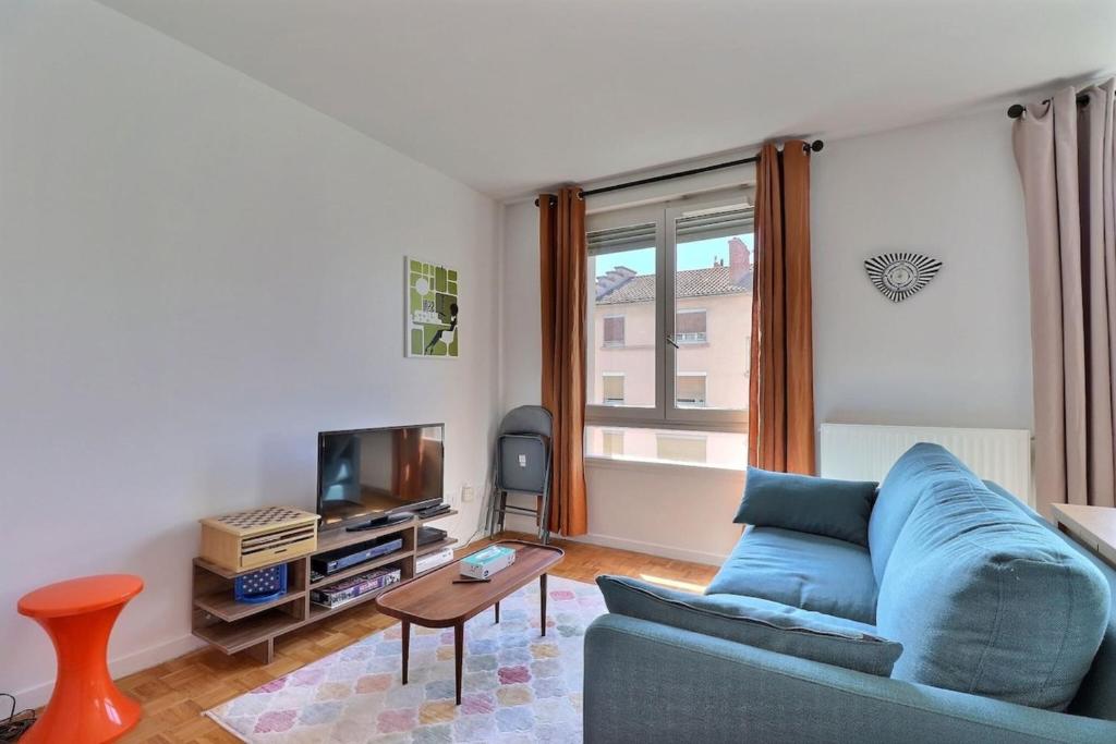 un salon avec un canapé bleu et une télévision dans l'établissement La Douce Parenthèse - Studio with garage - Lyon 4th, à Lyon