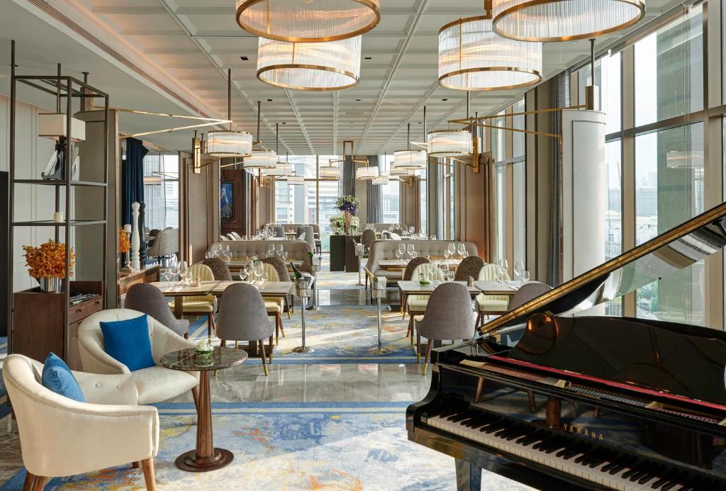 A bright hotel lounge with a grand piano, seating, and large windows.