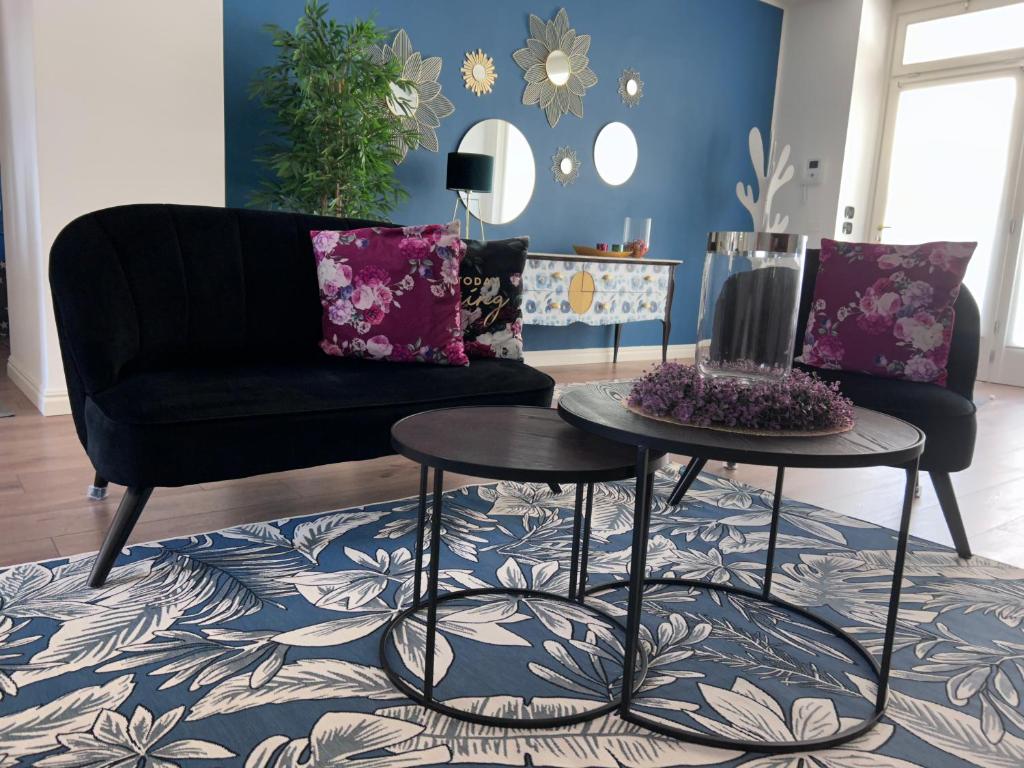 a living room with a black couch and two tables at Al Viale 2 in Negrar