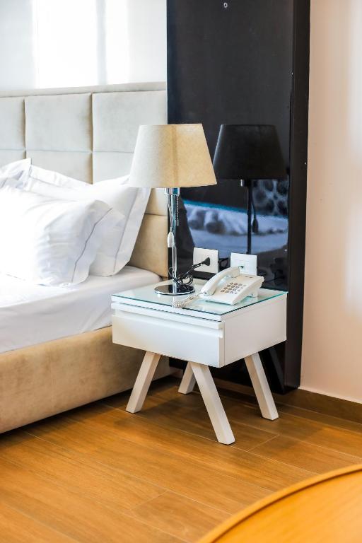 a table with a lamp on it next to a bed at Sole Luna Hotel in Borsh