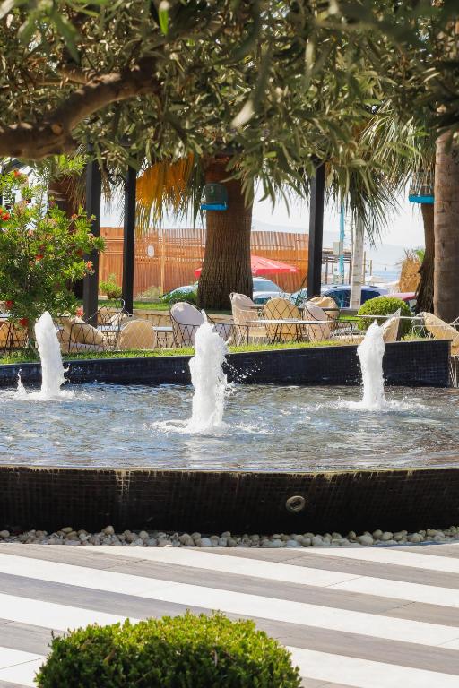 a fountain with water fountains in a park at Sole Luna Hotel in Borsh