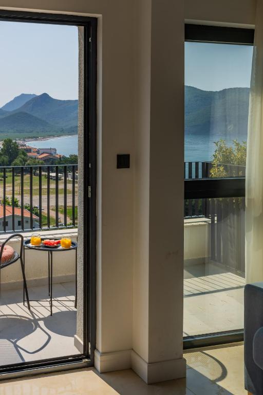 a door leading to a balcony with a table at Hotel AQUILO in Petrovac na Moru