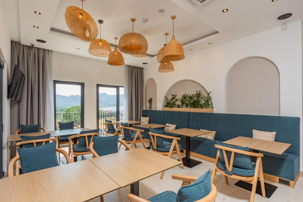 a restaurant with wooden tables and blue chairs at Hotel AQUILO in Petrovac na Moru