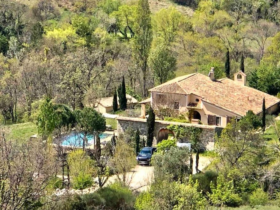 une maison avec une voiture garée devant dans l'établissement Mas d'exception en pierre avec piscine et vue, à La Roche-sur-le-Buis