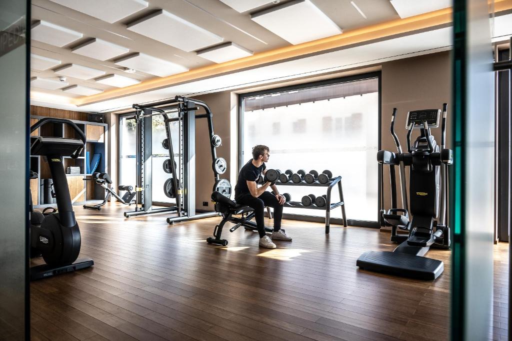 a man sitting on a bench in a gym at Ciampedie Luxury Alpine Spa Hotel in Vigo di Fassa