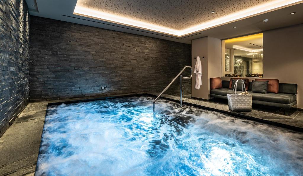 a hot tub in the middle of a room at Ciampedie Luxury Alpine Spa Hotel in Vigo di Fassa
