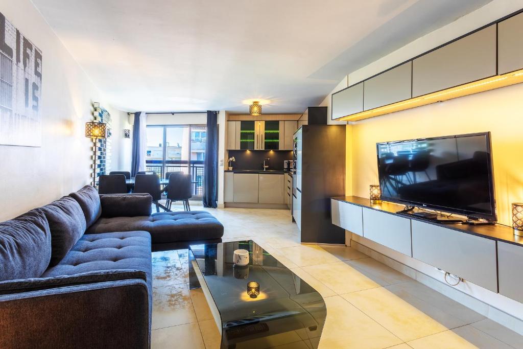 un salon avec un canapé bleu et une télévision dans l'établissement Suquet Du Midi MAR323 4P, à Cannes