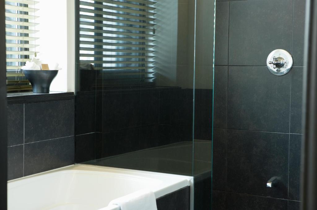 a bathroom with a shower with a glass door at Hôtel Le Germain Québec in Quebec City