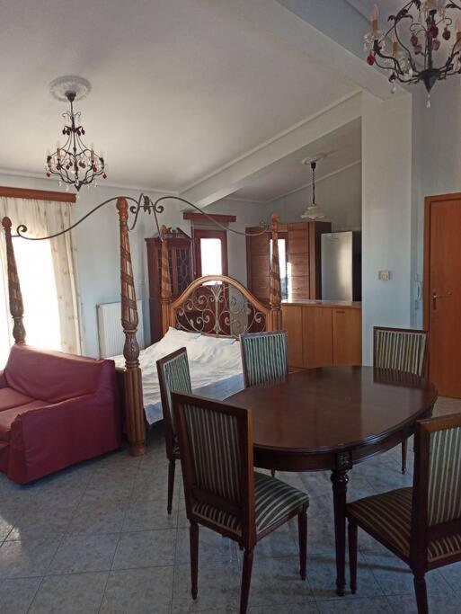 a living room with a dining room table and a bed at Nea Peramos Apartment-2 in Nea Peramos