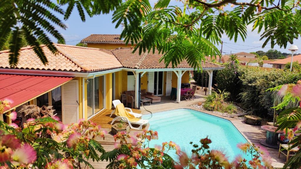 une maison avec une piscine dans la cour dans l'établissement Villa Soleil piscine, à Gujan-Mestras