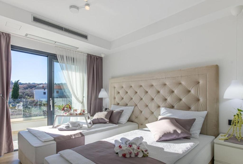 a bedroom with two beds and a large window at Luxury Villa Milly Heated indoor and outdoor pool in Vrh