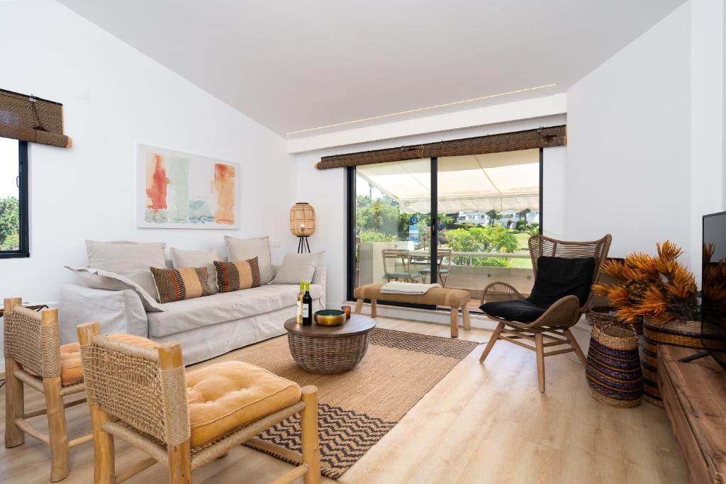 a living room with a couch and chairs at Quinta do Lago Luxury Beach Apartment in Almancil