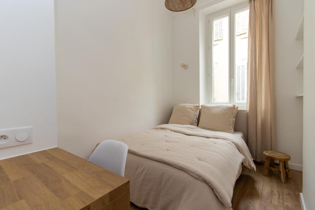 une chambre avec un lit avec une table et une fenêtre dans l'établissement Moderne T3 avec 2 chambres, à Marseille