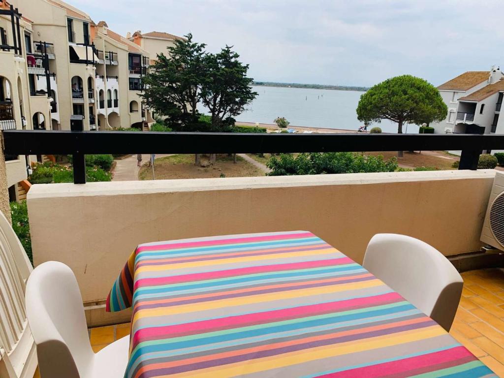 - une table colorée sur un balcon avec vue sur l'océan dans l'établissement Appartement 2 Pièces avec Terrasse, Accès Piscine et Activités Sportives - 4 Couchages, Clim en Option - FR-1-195-89, au Barcarès
