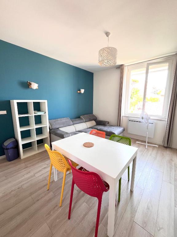 un salon avec une table et des chaises blanches dans l'établissement Appartement Calme en Plein Centre Ville, à Marseille