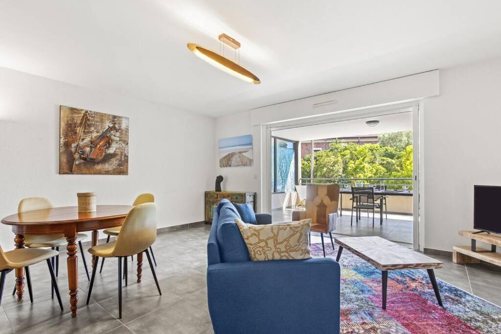 un salon avec un canapé bleu et une table dans l'établissement Apprt 2 cham, proche du centre, wifi, climatisation, San Giovanni, à Saint-Raphaël