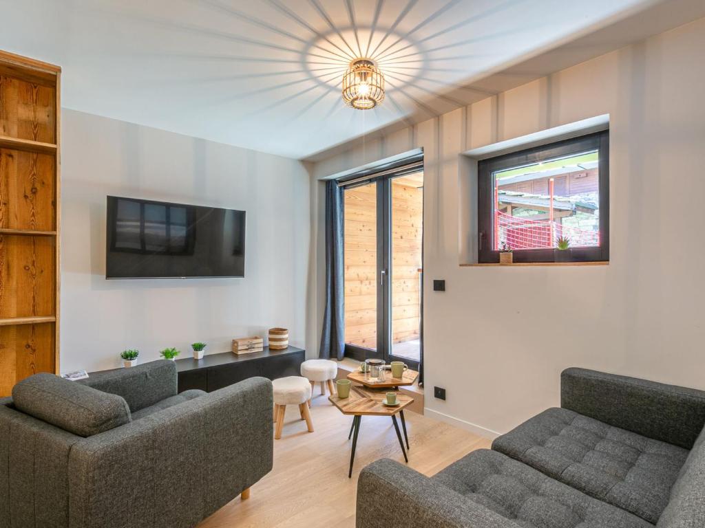 un salon avec deux canapés et une télévision dans l'établissement Cocon intime avec WiFi et garage au pied des pistes – résidence neuve de standing - FR-1-694-338, à Val dʼIsère