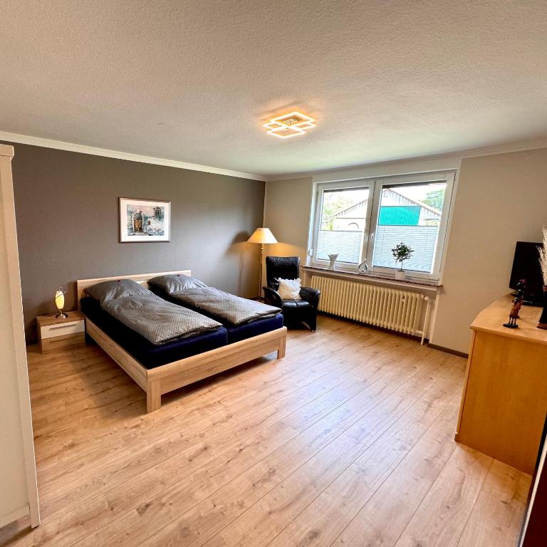 a bedroom with a bed and a chair in it at Ferienwohnung Bohlen in Wehden