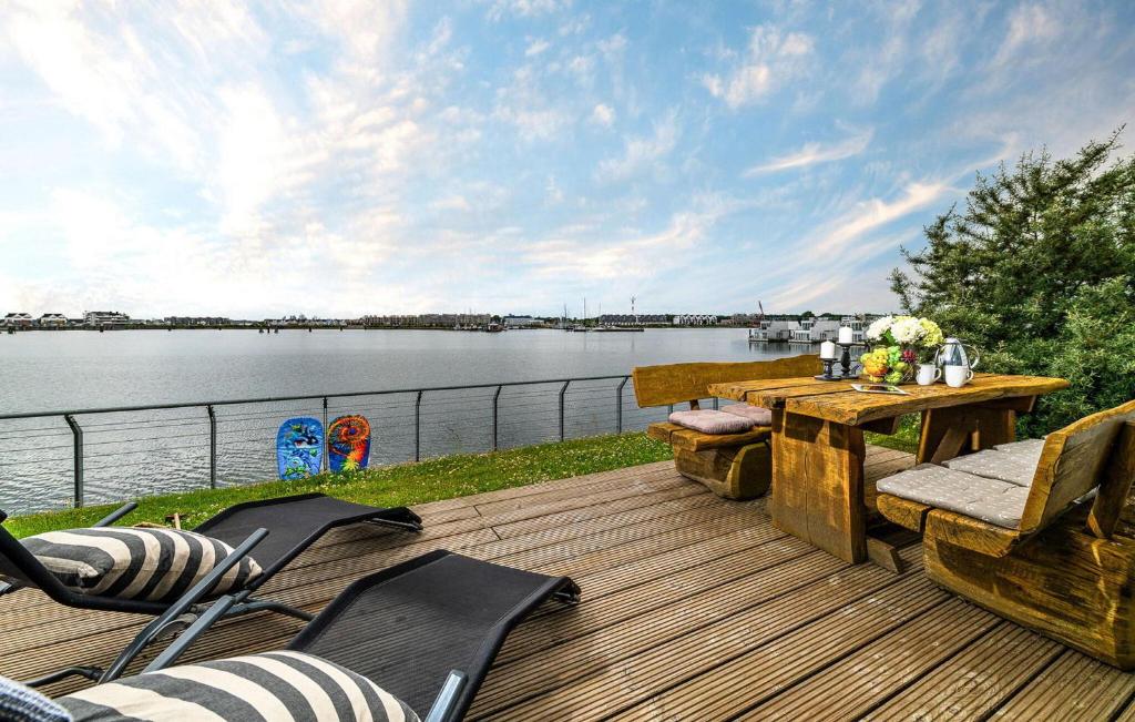 a wooden deck with a table and chairs next to the water at Deck 47 in Olpenitz