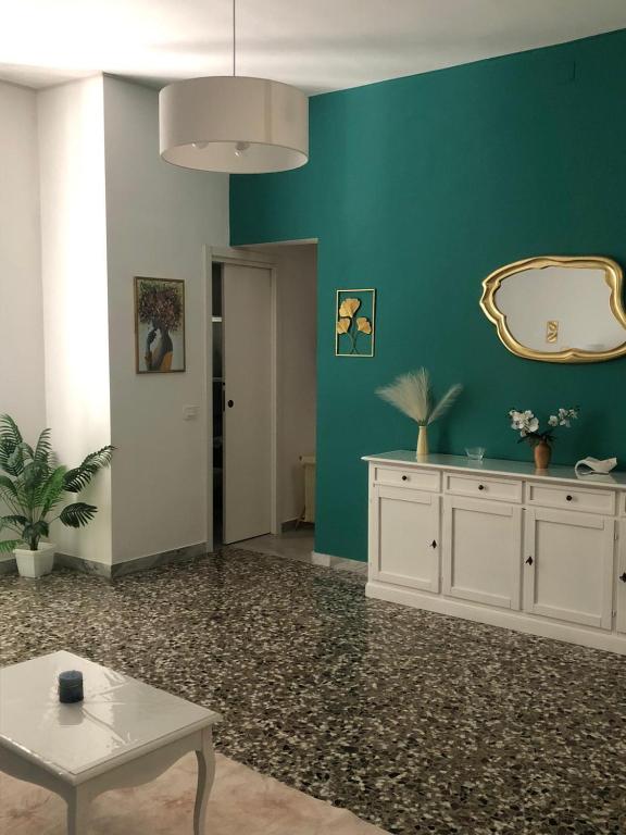 ein Wohnzimmer mit grünen Wänden und einem Tisch in der Unterkunft Dimora Gallo in Fasano
