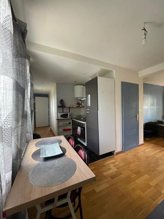 un salon avec une table et une cuisine dans l'établissement Appartement traversant avec balcon et belle vue sur jardin, proche des commodités et à moins de 30 minutes de Paris en transport, à Chennevières-sur-Marne
