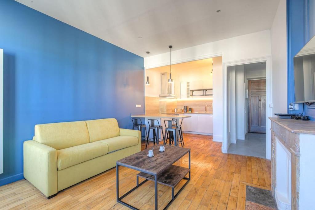 un salon avec un canapé et une table dans l'établissement Bel appartement lumineux, Croix-Rousse - Hôpitaux, à Lyon