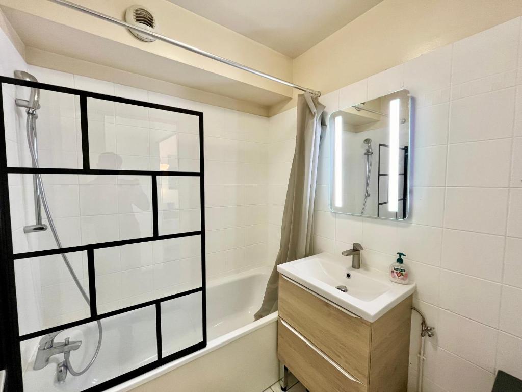 une salle de bain avec un lavabo et une douche dans l'établissement Le Forville Centre avec Parking, à Reims