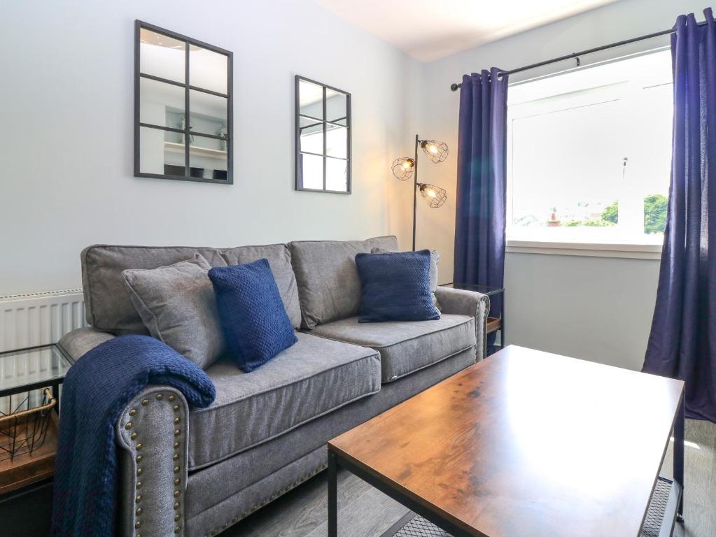a living room with a couch and a table at 7 High Buckholmside in Galashiels