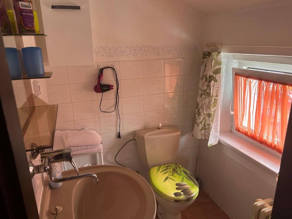a bathroom with a toilet and a sink and a window at Diamant in Karlovy Vary