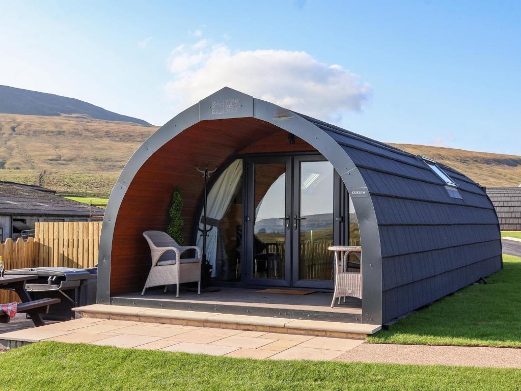 a gazebo with a table and chairs in a yard at Curlew in Carnforth