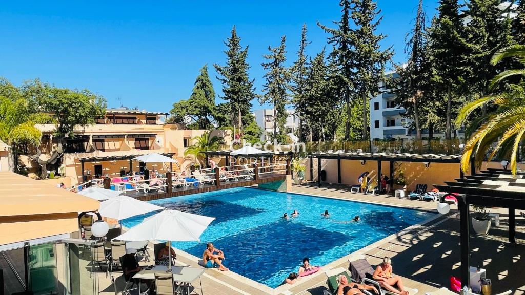 a pool at a hotel with people in it at Mar by Check-in Portugal in Albufeira