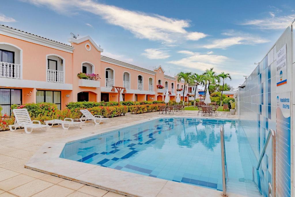 a swimming pool in front of a building at GB103 Village a 150m da Praia em Guarajuba, 2/4 in Guarajuba