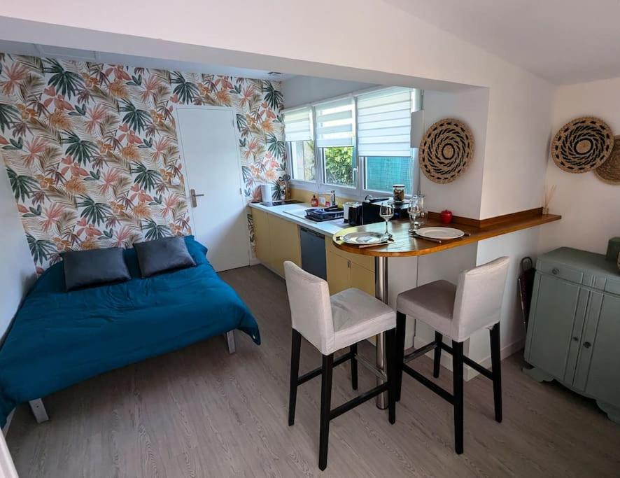 une chambre avec un lit et un bureau et une cuisine dans l'établissement Maisonnette centre-ville, à Caen