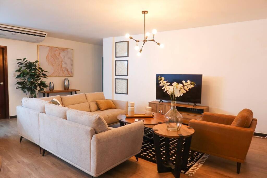 a living room with two couches and a table at Prime Location Stylish Apartment in San Pedro Sula