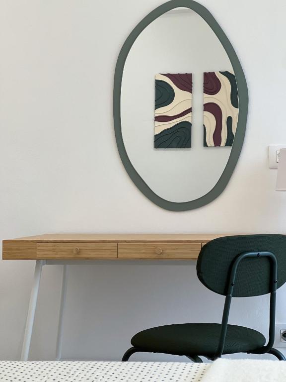 a mirror above a table with a green chair at Casa dei Sogni in Scalea