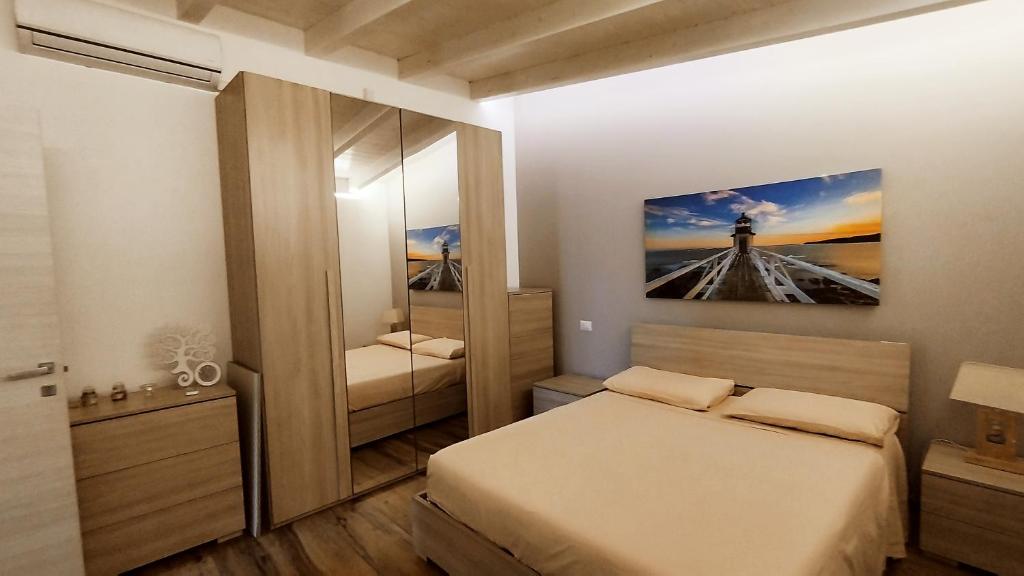 een slaapkamer met twee bedden en een grote spiegel bij Alle Volte Maison in Grumo Appula