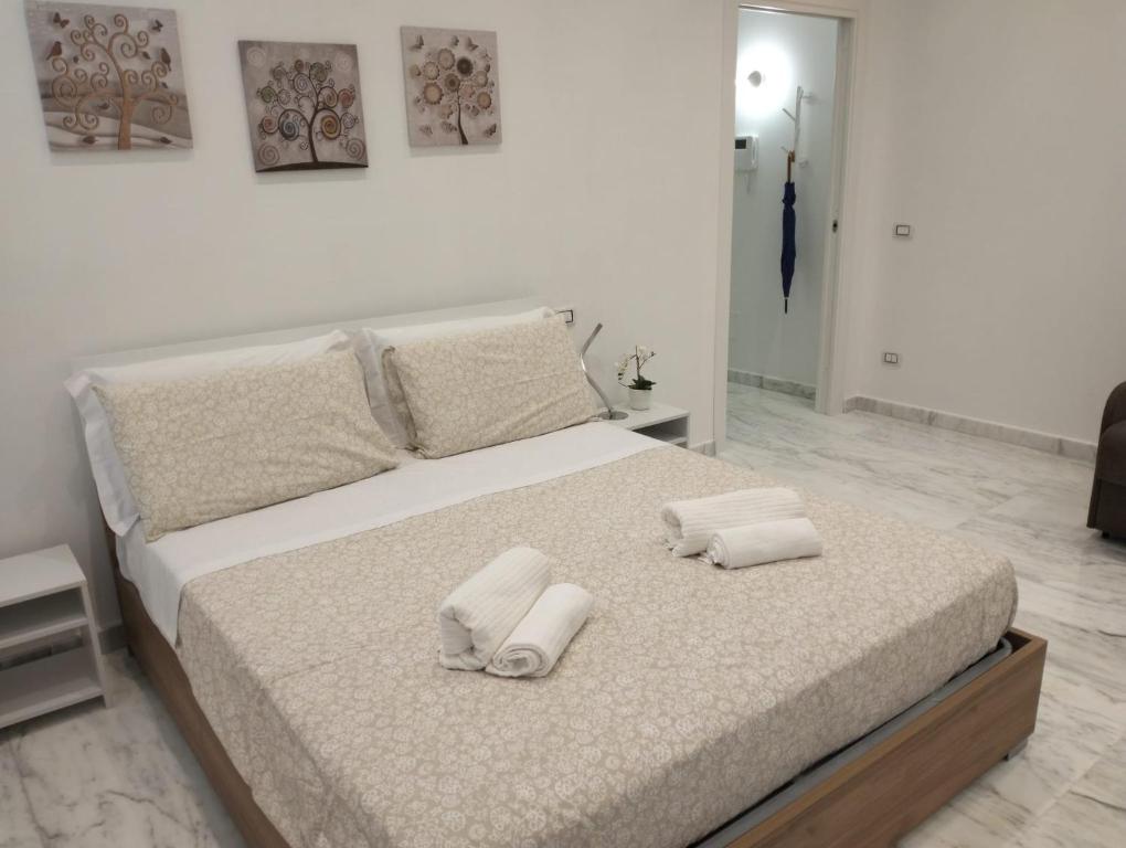 een slaapkamer met een bed met twee handdoeken erop bij Lily Suite 10 in Palermo