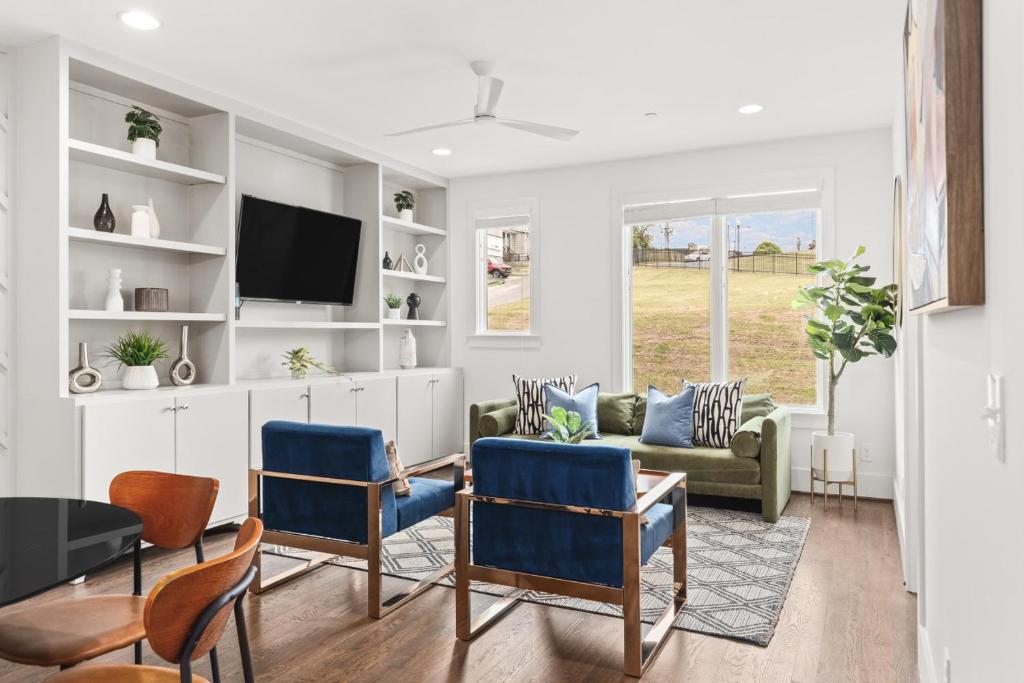 Una sala de estar con un sofá y un televisor. en Walk to 12 South and Belmont with Garage FirePit and Patio, en Nashville