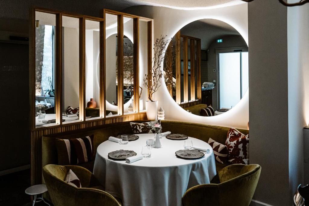 a dining room with a table and chairs and a mirror at Auberge De Saint-Rémy - Hôtel & Villa - Restaurant Gastronomique 2 Étoiles in Saint-Rémy-de-Provence