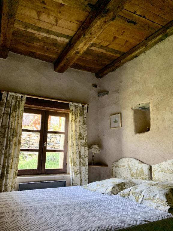une chambre avec un lit et une fenêtre dans l'établissement Jourcins Jardin avec vue Montagne, à Saint-André-dʼEmbrun