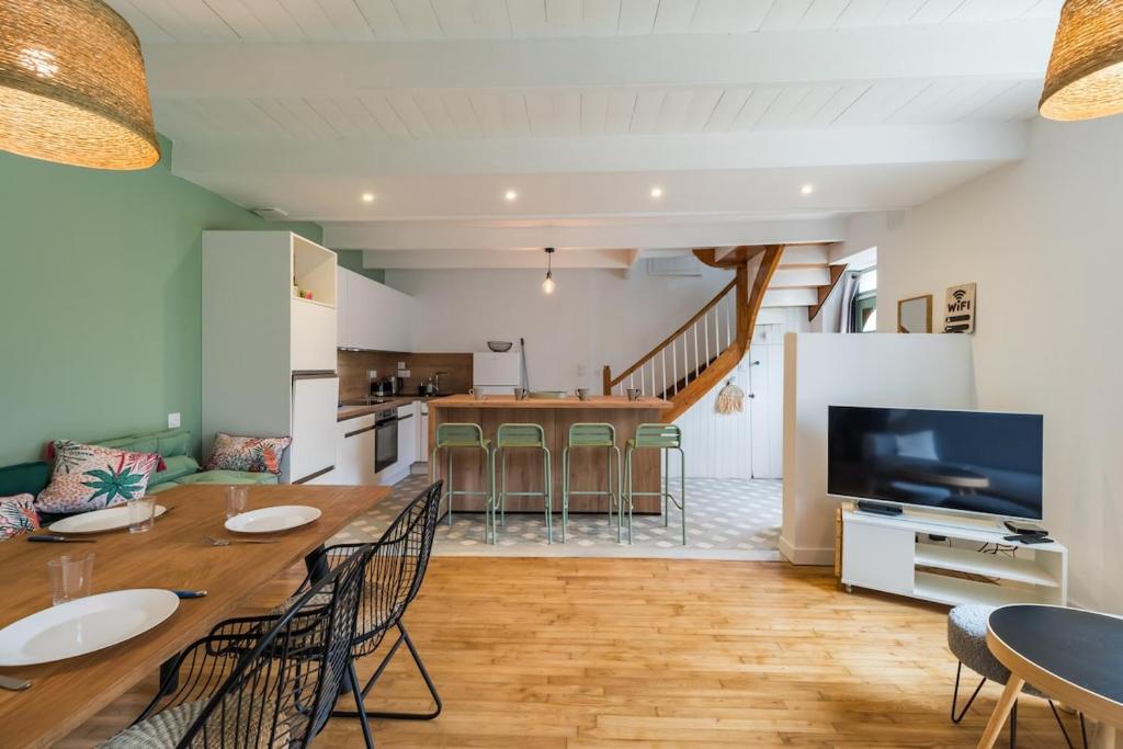 a kitchen and living room with a large table and chairs at Charmante Maison sur le port Loguivy de la Mer in Ploubazlanec