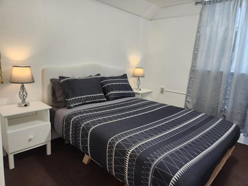 a bedroom with a bed and two lamps and a window at Eight Street Apartments in Long Beach